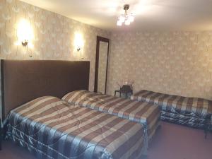 a hotel room with two beds in a room at Hôtel de La Croix d'Or in Avranches