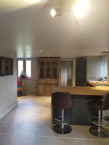 a kitchen with a counter and some chairs in it at Coed Canol Farm in Abergavenny