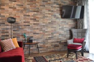 a living room with a couch and a brick wall at Casa di Alex | Sirmione in Sirmione
