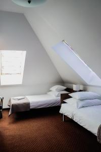 two beds in a room with a roof at Kalinowy Sen in Warsaw