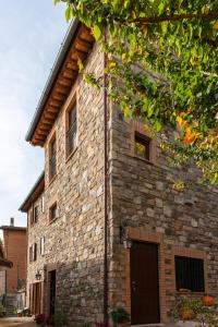 um grande edifício de pedra com uma porta em frente em Locanda della Rocca em Sarnano