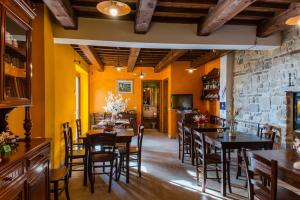 a dining room with tables and chairs and a stone wall at Locanda della Rocca in Sarnano