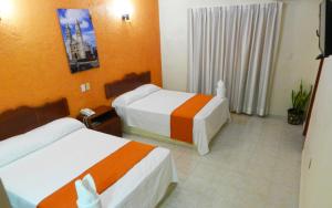 ein Hotelzimmer mit 2 Betten und orangefarbenen Wänden in der Unterkunft Hotel Uxulkah in Campeche