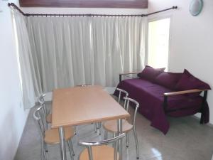 Habitación con cama, mesa y sillas. en Cabañas Tintihuasi en Villa Las Rosas