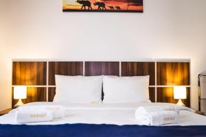 a bedroom with a large bed with two white pillows at Hideout Apartment in Predeal