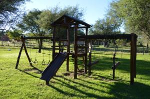 a playground with a swing set in a park at Cabañas Tintihuasi in Villa de Las Rosas