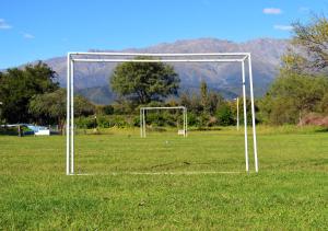 a soccer goal in a field with mountains in the background at Cabañas Tintihuasi in Villa de Las Rosas