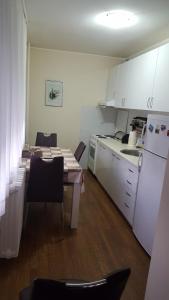 a kitchen with a table and a kitchen with white appliances at Apartman Jogi in Vračar (historical)