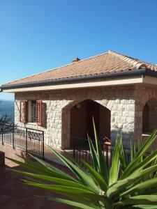 a small stone building with a fence in front at Villa Verde in Cefalù