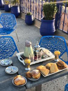 a table with a tray of bread and pastries on it at Riad Dar Essassi 23 in Marrakech