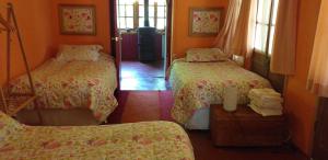 a room with two beds and a mirror in a room at La Casa de Adobe Natural y Más in Bulnes