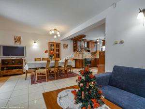 a living room with a blue couch and a christmas tree at Dom MAJA 10-12 osób w górach, Krościenko nad Dunajcem, Szczawnica, Kluszkowce in Krościenko