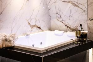 a bathtub in a bathroom with a marble wall at Municipio Luxury Suite in Naples