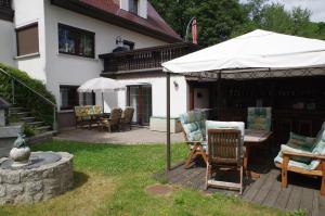 un patio con mesa y sillas bajo una sombrilla en Gästehaus Gaens - Ferienzimmer, en Schirgiswalde