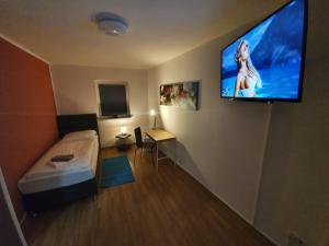 a room with a television and a bed in it at White Pearl Hostel 2 in Nuremberg