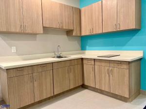 an empty kitchen with wooden cabinets and a sink at Americas Best Value Inn Houston Willowbrook in Houston