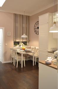 札格雷布的住宿－City Centre Dream place，厨房以及带白色桌椅的用餐室。