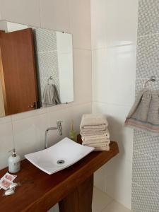 a bathroom with a white sink and a mirror at Hotel Zona Sul in São Gabriel