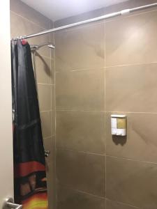 La salle de bains est pourvue d'une douche avec rideau de douche noir. dans l'établissement DEPARTAMENTO DE 2 DORMITORIOS C/ COCHERA, à Villa María