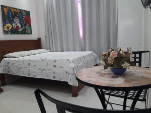 a room with a bed and a table with a table sidx sidx sidx at Studio Santa Clara in Rio de Janeiro