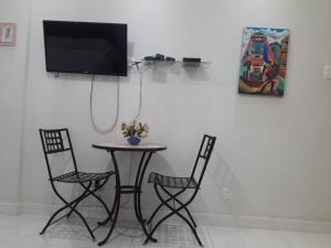 mesa con 2 sillas y TV en la pared en Studio Santa Clara, en Río de Janeiro