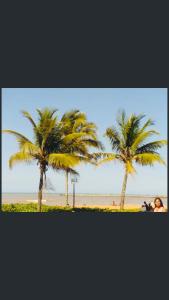 two palm trees in front of the beach at Casa quadra praia Jacaraipe! in Jacaraípe