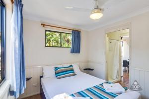 Un dormitorio con dos camas y una ventana. en Coral Coast Tourist Park, en Townsville