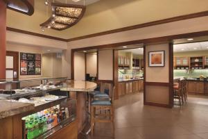 a restaurant with a counter and a bar with drinks at Hyatt Place Chicago Hoffman Estates in Hoffman Estates