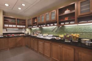 a kitchen with wooden cabinets and food on the counters at Hyatt Place Chicago Hoffman Estates in Hoffman Estates