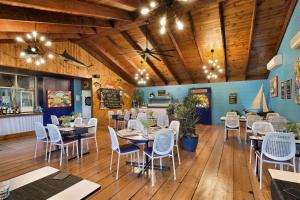 a dining room with tables and chairs and wooden ceilings at Barrier Reef Motel Innisfail in Innisfail