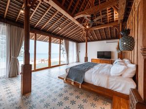 a bedroom with a bed with a view of the ocean at Villa Victoria Nusa Penida in Nusa Penida