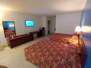 a hotel room with a bed and a flat screen tv at Relax Inn Silver Springs in Silver Springs