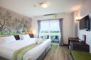 a hotel room with a large bed and a window at Hill Fresco Hotel in Pattaya South