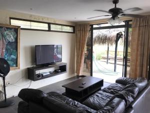 a living room with a couch and a flat screen tv at The Heights in Montañita in Montañita