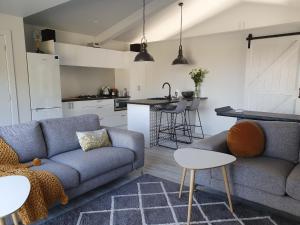 uma sala de estar com um sofá e uma cozinha em Garden View Cottage em Carterton