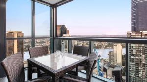 a dining room with a balcony overlooking a city at Oaks Brisbane on Charlotte Suites in Brisbane