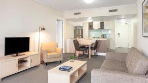 a living room filled with furniture and a tv at Oaks Brisbane on Charlotte Suites in Brisbane