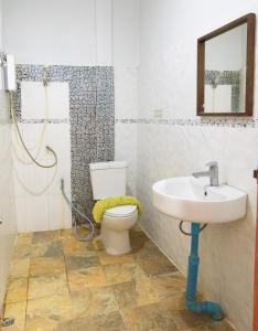 een badkamer met een wastafel, een toilet en een spiegel bij Tree House Resort Betong in Betong