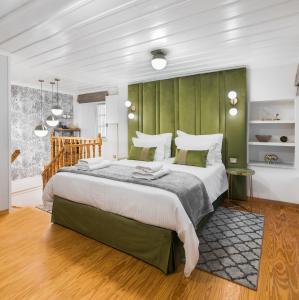 a bedroom with a large bed with a green headboard at Mavrogenous Luxury Apartments in Nafplio
