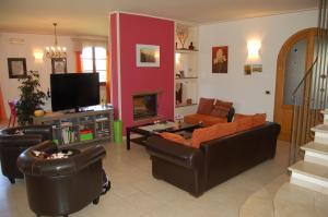 a living room with couches and a flat screen tv at Villa Iriscortona in Cortona