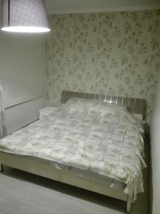 a bed in a bedroom with a wall at Двухкомнатная квартира Smart-Home in Daugavpils