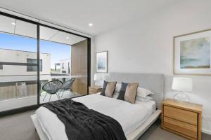 a bedroom with a bed and a large window at Stunning Main Beach Location- Anglesea in Anglesea