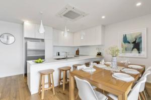a kitchen and dining room with a wooden table and chairs at Stunning Main Beach Location- Anglesea in Anglesea