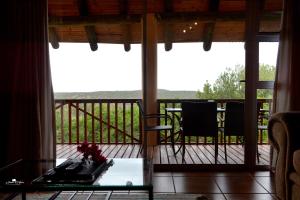 a screened in porch with a table and two chairs at Kududu Guest House in Addo