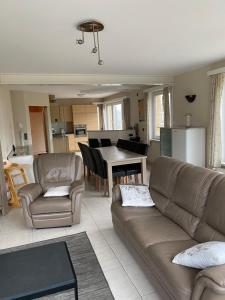 - un salon avec un canapé et une table dans l'établissement Westhoek Apartments, à La Panne