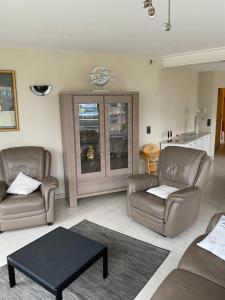 ein Wohnzimmer mit 2 Stühlen und einem Tisch in der Unterkunft Westhoek Apartments in De Panne