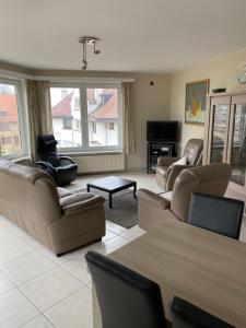 ein Wohnzimmer mit Sofas und einem Flachbild-TV in der Unterkunft Westhoek Apartments in De Panne