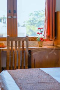 einem Holzstuhl neben einem Schreibtisch mit Pflanze in der Unterkunft The Pub Hotel in Olongapo