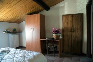 a bedroom with a bed and a desk and a cabinet at IL TRAMONTO SUL PO in Calendasco