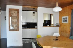 a kitchen and dining room with a wooden table at Chalet Bietschhorn Rosswald in Termen